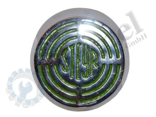 Steyr Zeichen auf der Motorhaube, Aluminium, Logo verchromt, Hintergrund grün