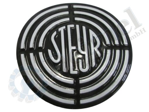 Steyr Motorhauben Emblem gewölbt, schwarz mit weißer Zielscheibe und Schrift, Ansicht von vorne